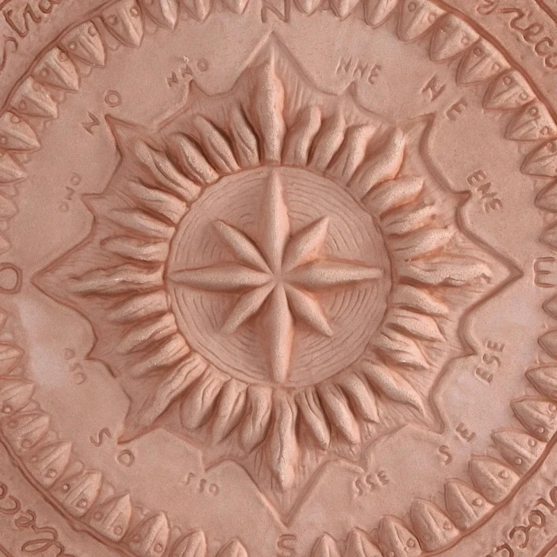 Bas-relief de la rose des vents en terre cuite