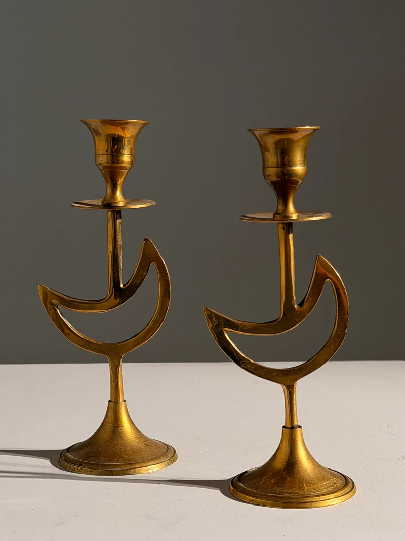 Pair of brass candlesticks with a crescent-moon motif, France, circa 1970