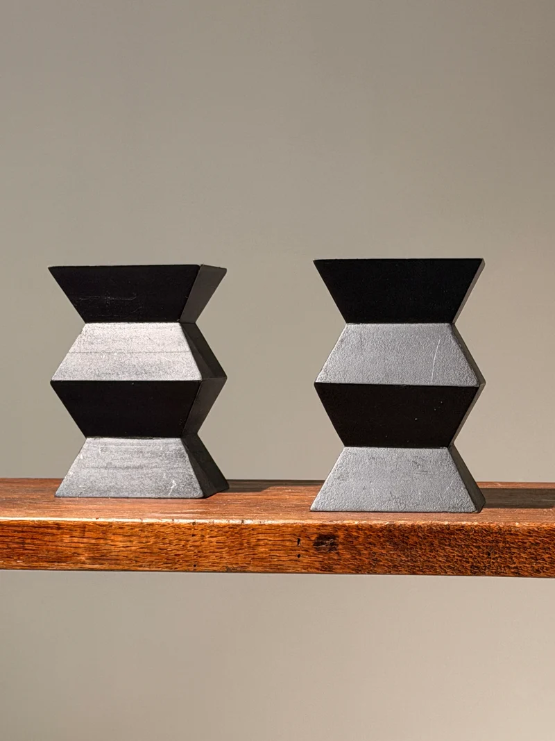Pair of geometric black wooden candlesticks, anonymous work